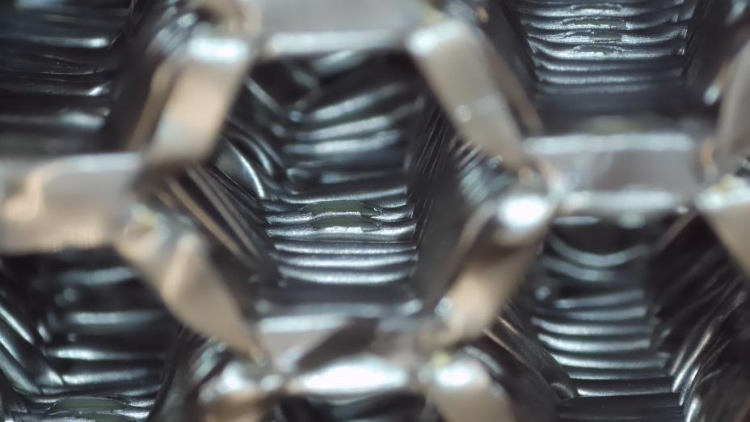 Close-up view of bent and buckled honeycomb cell walls after compression
