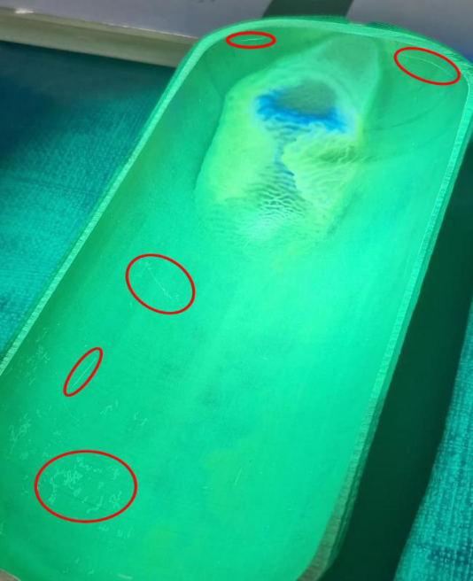Test surface under UV light showing five damage areas